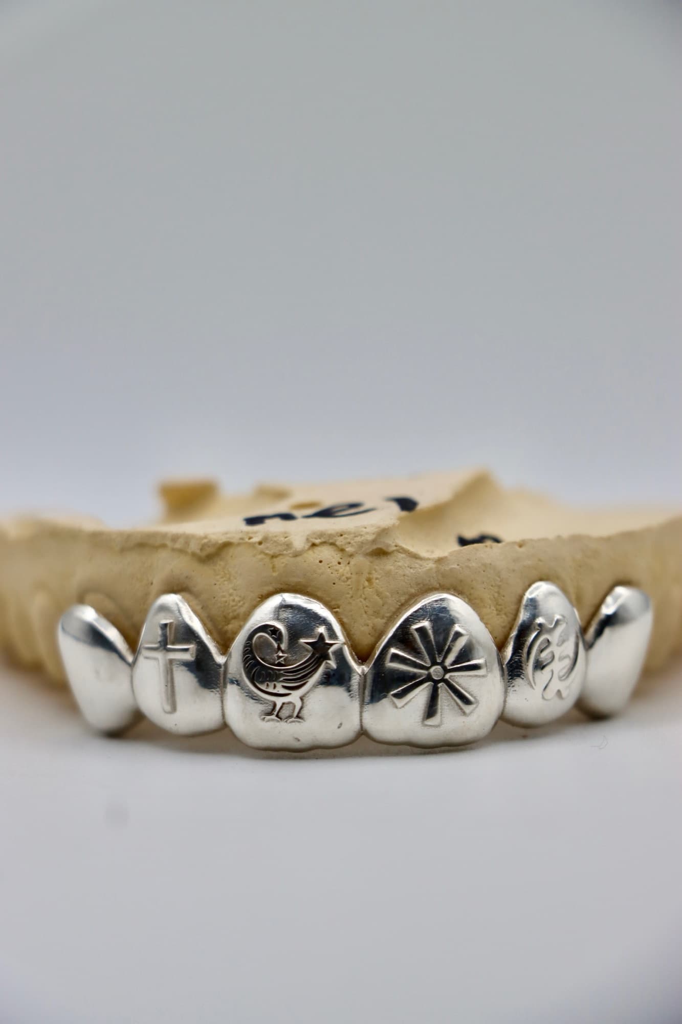 Six-tooth solid silver set engraved with Adinkra symbols