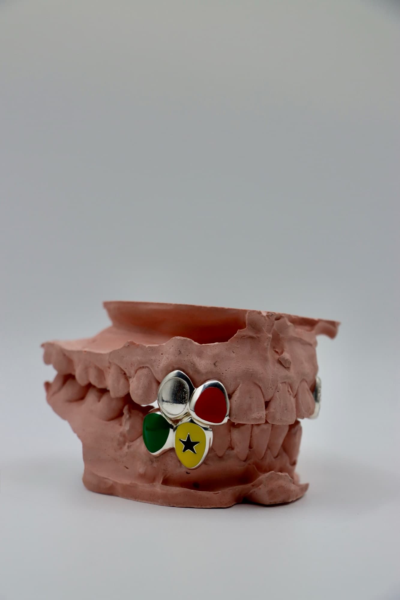 Silver set with red, green and yellow enamel and a black star