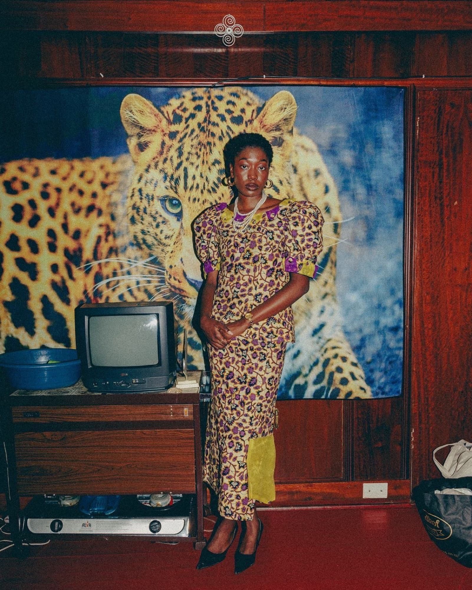 Portrait in wax print in front of a leopard backdrop