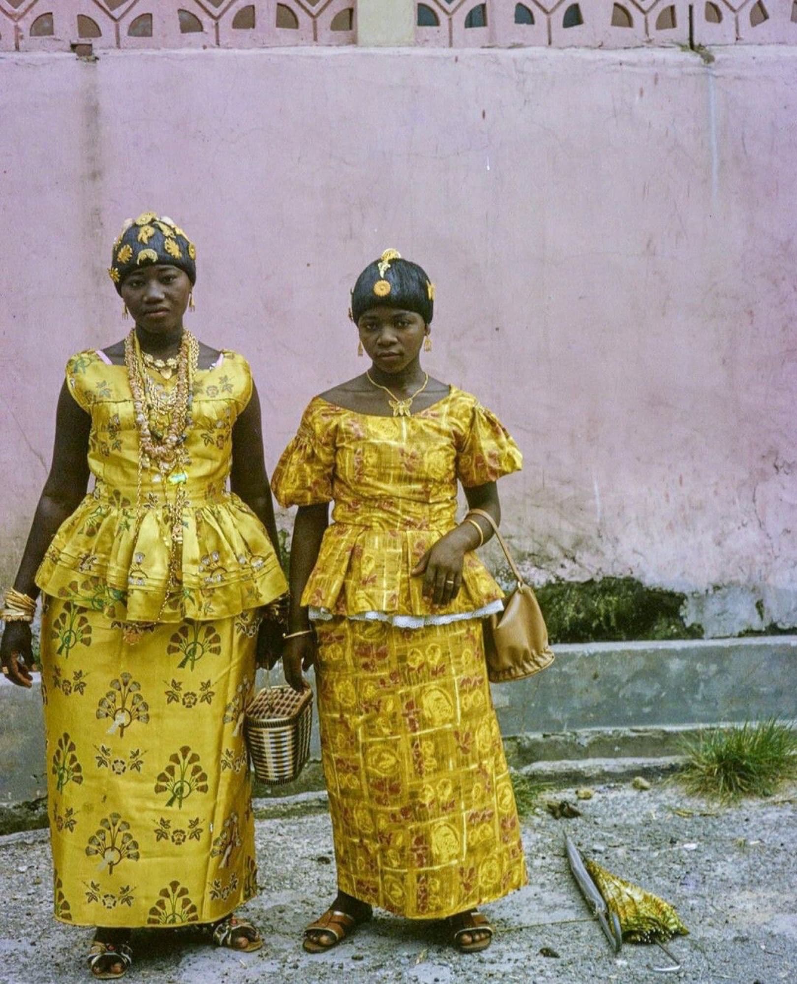 Two women in gold dresses and jewelry